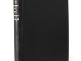 a black book with gold lettering on it sitting on a white surface