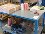 un chariot bleu chargé de cartons dans un entrepôt