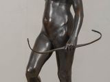 statue of a woman with a whip on a wooden table