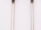 two spoons and a fork on a white surface
