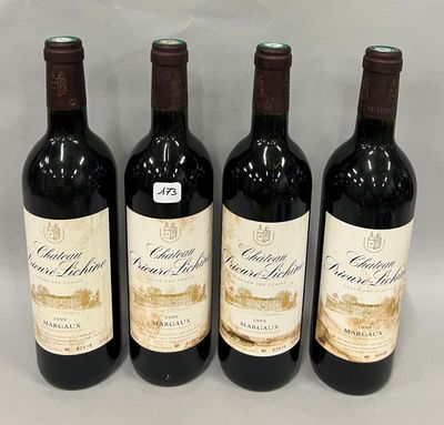 trois bouteilles de vin rouge sont alignées sur une table