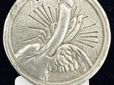 Gros plan sur une pièce d'argent ornée d'un oiseau