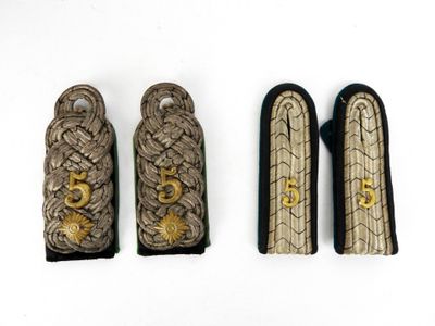 trois types différents d'uniformes militaires exposés sur un fond blanc