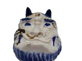 a small blue and white cat head on a white surface
