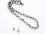 gros plan d'un collier et de boucles d'oreilles sur une surface blanche