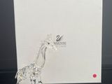 une figurine de girafe en verre posée sur une table