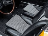 the interior of a car with a checkered seat and steering wheel