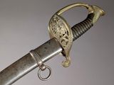 an old sword with a metal handle on a gray background