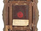 an old picture frame with a red flower on it