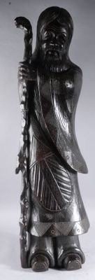 statue représentant un homme tenant un bâton et un bâton à la main