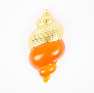 une photo en gros plan d'une broche surmontée d'un coquillage