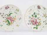 deux assiettes ornées de fleurs et de feuilles, posées sur un fond blanc