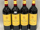 four bottles of red wine are lined up on a white surface