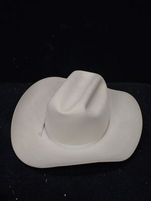 un chapeau de cow-boy blanc posé sur une surface noire