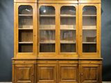 an old wooden china cabinet with glass doors and shelves