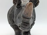 a rhino figurine that is standing on a white surface