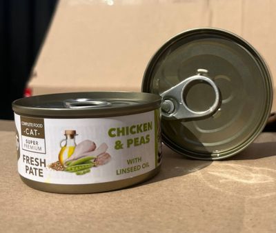 une boîte de poulet aux petits pois à côté d'un ouvre-boîte
