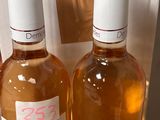 trois bouteilles de vin posées sur une table, à côté d'un carton