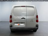the back of a silver van parked inside of a building