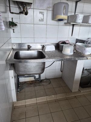 une cuisine équipée d'un évier, d'une cuisinière et d'autres éléments