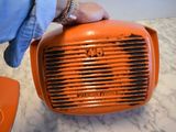 a person holding an orange radio on a marble table