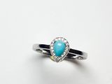 un gros plan d'une bague sertie d'une pierre de turquoise