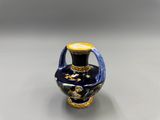 un petit vase bleu orné d'un motif doré