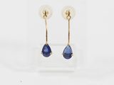 une paire de boucles d'oreilles en saphir bleu présentée dans un écrin transparent
