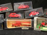 six petites voitures rouges dans une vitrine sur fond noir