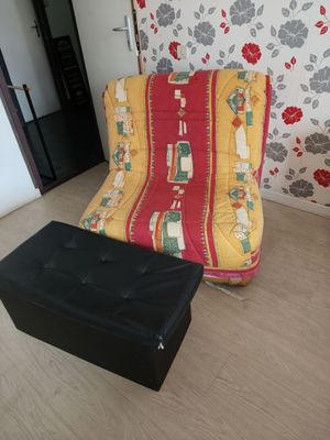 a futon chair and ottoman in the corner of a room