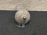 a silver object sitting on a black surface