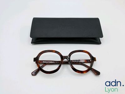glasses and case on a white surface with a logo on it