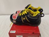 boys ' s black and yellow athletic shoes with yellow laces on top of a red box