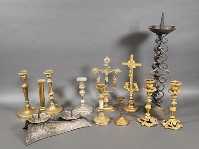 many different types of candles and candlesticks on the table