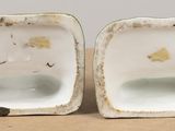 two pieces of porcelain sitting on top of a table