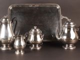 a silver tray with a silver tea set on top of it