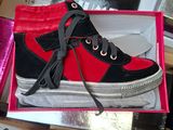 a red and black shoe in a box on a table