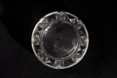 a glass plate with a design on it on a black surface