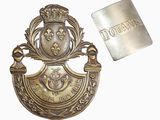 une image représentant un insigne métallique auquel est attachée une étiquette métallique