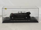 an old model of a black car in a clear display case