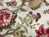 a close up of a bed with a red and green floral pattern on it