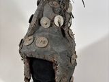 an old helmet with buttons on it sitting on top of a white surface