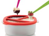 un bol de chocolat et de fraises avec une cuillère dedans