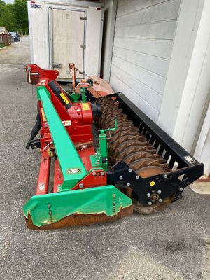 une photo d'une machine agricole garée devant un bâtiment