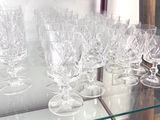 many wine glasses sitting on a glass shelf in a glass case