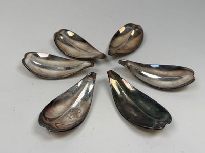 six cuillères sont disposées en cercle sur une table