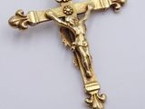 a gold cross with a crown on it on a white surface