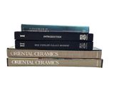 trois livres empilés sur une surface blanche