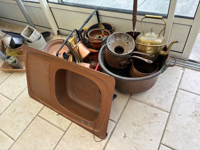 des casseroles et des poêles sont posées par terre devant une fenêtre