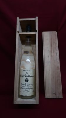 an empty bottle of wine in a wooden box on a red cloth